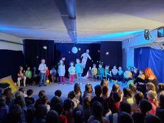 dzieci siedzą na podłodze i stoją w półkole