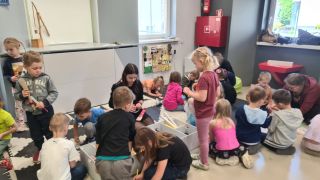 dzieci siedzą na podłodze, wykonują prace plastyczne