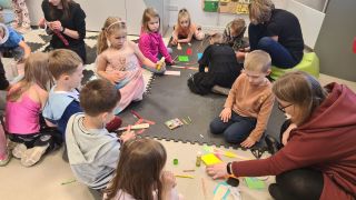 dzieci siedzą na podłodze, wykonują prace plastyczne