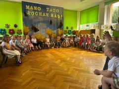 dzieci siedzą na krzesełkach recytują