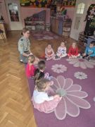 dzieci siedzą na dywanie słuchają Harcerki