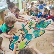 Dzieci kolorują przy stolikach dinozaura xl
