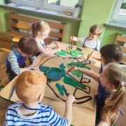 Dzieci kolorują przy stolikach dinozaura xl