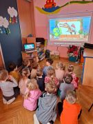 Dzieci oglądają film na tablicy multimedialnej