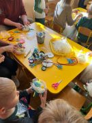 Dzieci z rodzicami przygotowują ozdoby wielkanocne
