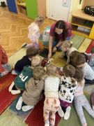 Dzieci uważnie słuchają panią prowadzącą zajęcia.