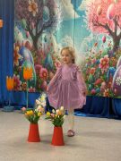 Dziewczynka w różowej sukience recytuje wiersz