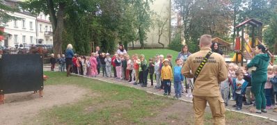 Strażak odbiera meldunek od nauczycieli