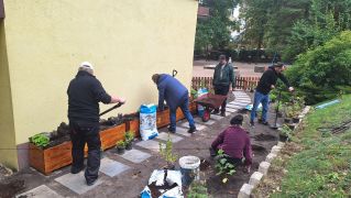 Rodzice sadzą rośliny w ogrodzie