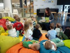 Dzieci siedząc na pufach słuchają opowieści.