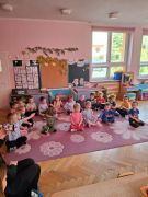 Dzieci siedzą po turecku na podłodze.