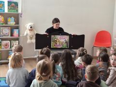 Dzieci w bibliotece słuchają bajki.