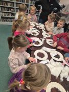 Dzieci w bibliotece wykonują prace.