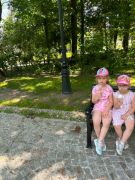 Dziewczyny jedzą lody siedząc na ławce.
