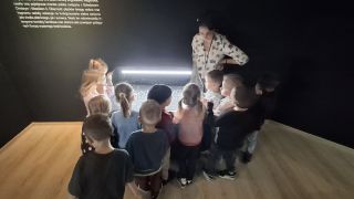 Dzieci oglądają wystawę w muzeum.
